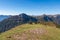 Goldeck - Herd of wild horses grazing on alpine meadow with scenic view of magical mountain of Karawanks and Julian Alps