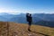 Goldeck - Man with baby carrier looking at magical mountain peaks of Karawanks and Julian Alps seen from Goldeck