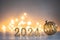 Golden 2024 new year numbers with a golden christmas ball on shiny background with soft atmospheric bokeh lights