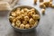 Golden airy popcorn in a gray plate on a concrete table on a piece of light burlap, fried crispy corn for watching a movie or