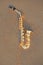 The golden alto saxophone lies on the sand or on the beach. Musical cover and creative. Design with copy space