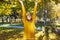 Golden autumn concept. Beautiful girl in a yellow sweater throws leaves up, outdoor portrait