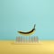 Golden banana floating above nail traps on yellow and blue pastel background color