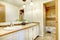 Golden bathroom interior with wood white painted cabinets and beige tiles