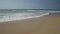 Golden beach meeting deep blue ocean water and foamy waves