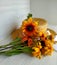 Golden bicolor rudbeckia lies on a wicker straw hat on a light wood background