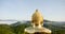 Golden Big buddha green hill mist on mountain range in morning. Panning Buddhist religion temple hill back view giant big buddha w