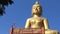 Golden big buddha with wood carving balcony and blue sky background