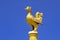 Golden bird statue soaring into blue sky at Thai temple