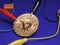 Golden Bitcoin with alligator clips