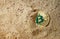 Golden Bitcoin coin buried in sand.