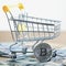 Golden bitcoin coin near shopping cart - symbol of crypto currency. Concept of purchases for bitcoin