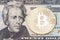 Golden bitcoin coin on twenty dollars banknote close up.