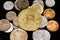 A golden Bitcoin with coins from Pakistan on a black reflective background