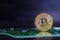 Golden bitcoin on green board with microchips and microcircuits on background.