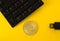 Golden bitcoin, keyboard and flash drive on a yellow background top view