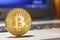 Golden bitcoin on the laptop touchpad closeup. Cryptocurrency virtual money