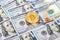 Golden bitcoin lying over american dollar bills