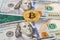 Golden bitcoin lying over american dollar bills and electronic b