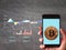 Golden bitcoin on mobile phone , Background graph on blackboard.