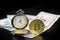 Golden bitcoin and pocket watch on us dollars standing on dark