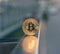 Golden bitcoin stand on metal handrail