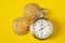 Golden bitcoin and stopwatch on yellow background