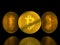 Golden bitcoin tokens on black background with reflection