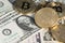 Golden Bitcoins on US dolllars close up image. Bitcoin virtual money and banknotes of dollars.