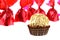 Golden bonbon in front of red sweets isolated