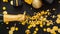 Golden bottle of champagne spills out gold sparkles in frame of gold festive Christmas decor confetti balls gifts on black