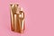 Golden bottles, cosmetic products on pink background. Luxury beauty style. Gold cosmetic containers. Mockup bottles, cosmetics