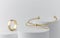 Golden bow shape Bracelet and triple ring on white cylinders with copy space