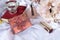 Golden box with red flowers and a bow, perfume bottle, book, candle, tube with lipstick, hydrangea flowers on white fabric