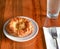 Golden brown apple pastry with crisp flaky texture on a rustic wood restaurant table.