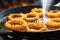 golden brown crispy onion rings frying