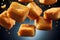 Golden Brown Fried Cheese Cubes Falling on Vibrant Dark Blue Background in Mid Air