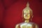 Golden Buddha against a red background