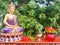 Golden Buddha Home center on wooden plank near neem tree with lotus on red glass - Incense flames in Brass - Red Flowers and gre