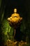Golden Buddha meditation statue on a lotus floating above the flower in a water in glitter emerald cave religious synonym about