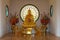 Golden Buddha sitting with hands clasped in contemplation on the