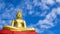 Golden Buddha statue against blue sky in Thailand temple