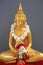 Golden Buddha statue with garland ob gray