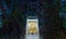 Golden Buddha statue with old brick wall and old tree roots through window at night in Wat Bang Kung in Samut Songkhram district,