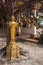 A golden Buddha statue under the wish tree with golden leaves at the Tiger Cave Buddhist temple in Krabi province in Thailand.