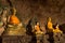 Golden buddha statues along the wall inside the cave