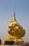 Golden buddhism pagoda on big stone