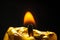 Golden candle burn on black background flame