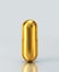 Golden capsule pill isolated on gray background. Clipping path included