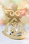 Golden Christmas angel figure, burning candle, colorful confetti lights in the background, festive atmosphere, greeting card